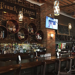 A bar, with various bottles displayed on circular shelves behind, under a 